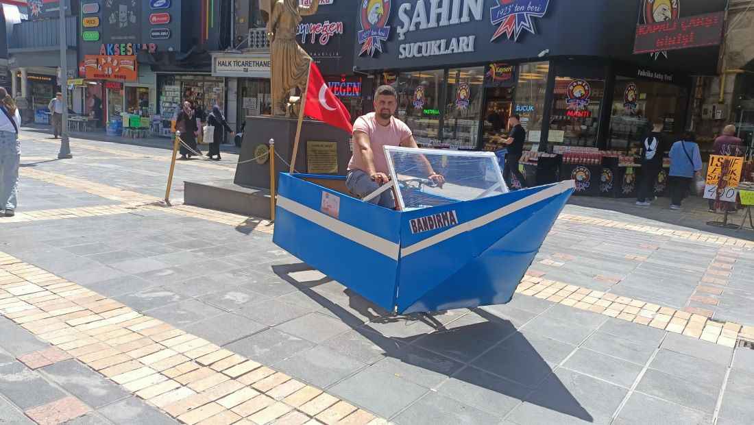 bisiklet-uzerine-yapmis-oldugu-kundura-araba-ve-helikopter-maketleriyle-sokaklarda-caddelerde-gezerek-vatandaslar-tarafindan-ilgi-toplayan-icerik-ureticisi-omer-bal-bu-kez-de-19-mayisa-ozel-yuruyen-gemi-maketi-tasarladi